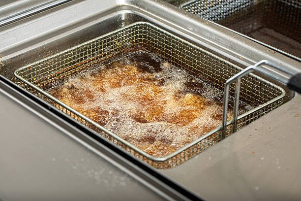 istock Frying golden chicken wings in deep fryer 2214090031