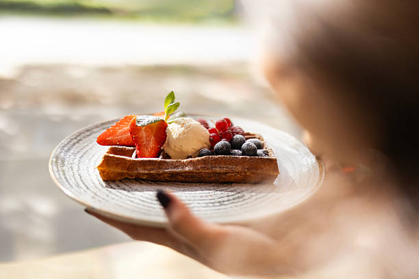 istock Young Woman Eating Waffles with Fruit and Ice Cream 2214093869