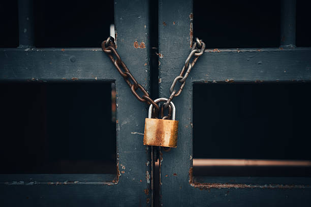istock Padlock and chain on an old metal fence 2214096324