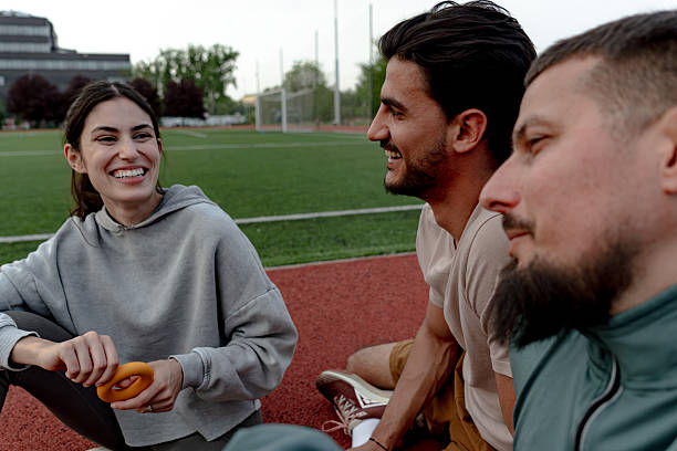 istock Athletes relaxing and chatting together on running track after training 2214103762