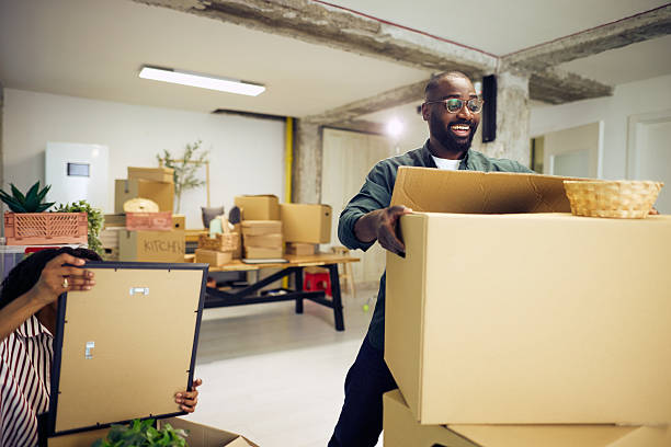 istock Happy couple unpacking cardboard boxes in new apartment 2214105148