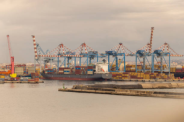 istock Large Container Ship Docked at Port With Active Industrial Cranes 2214106126