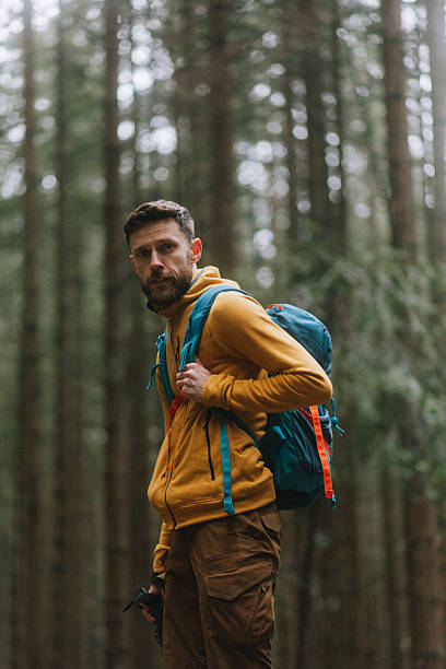 istock The handsome, smiling man hiker in the pine forest 2214106610