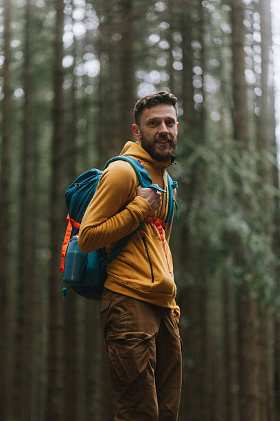 istock The handsome, smiling man hiker in the pine forest 2214106623