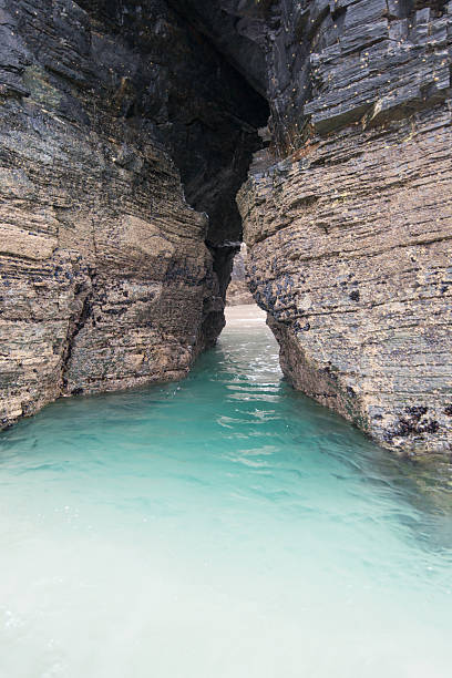 Beautiful transparent water. Cave in Cathedrals beach, Lugo, Spain. Cathedrals beach has been declared natural monument in Galicia.