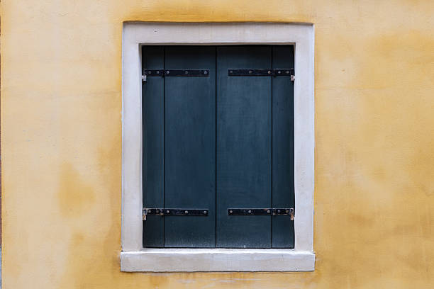 istock Closed Dark Shutters on Yellow Wall 2214108168
