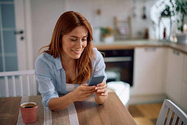 istock Happy woman text messaging on mobile phone at home. 2214112079