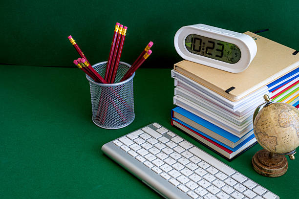 A vibrant assortment of school supplies including notebooks, pencils, markers, and scissors neatly arranged on a green background