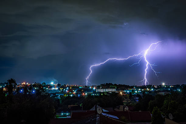 istock Multiple lightning strikes illuminate the night sky above a glowing urban landscape after sunset 2214115717