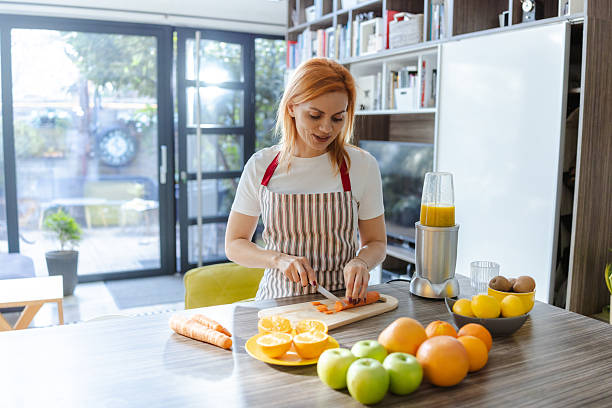 istock Woman preparing fresh fruit juice in a bright, modern living space 2214120916