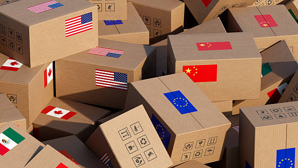 istock Chaotic pile of cardboard boxes with flags – Symbolizing Trade Tariffs and Global Trade Challenges 2214121803