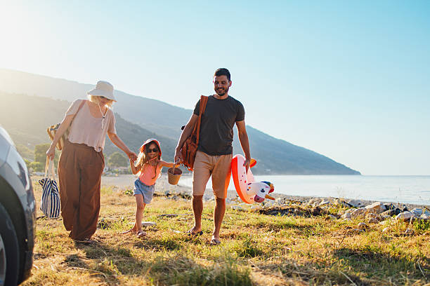 istock Happy Family Strolling on a Sunny Beach Vacation Day 2214123103