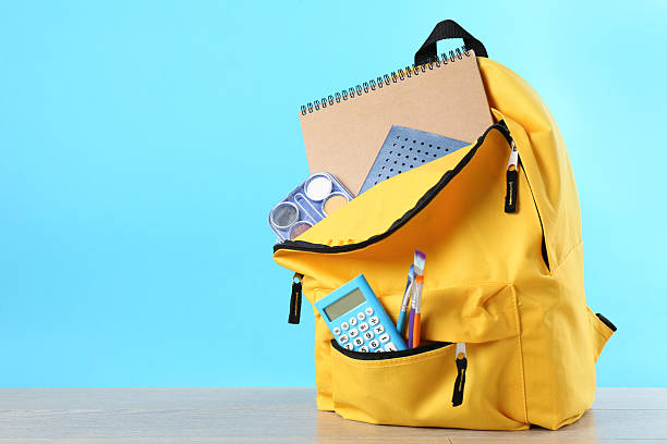 istock Backpack with different school stationery on wooden table against light blue background, space for text 2214128815