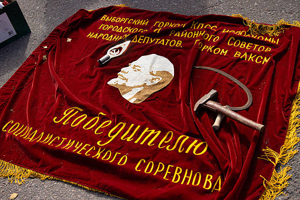 Tervasaari, Hamina, Finland, August 26th, 2023. Communist era red Soviet banner with Lenin profile and Russian text laying on the asphalt ground at a flea market.