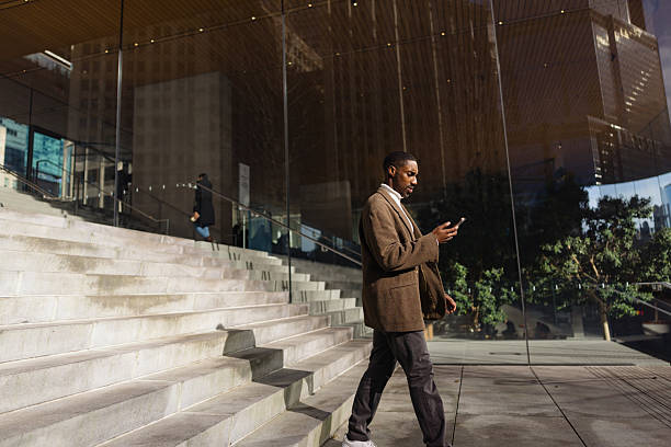 istock Businessman walking and using smartphone near modern building 2214138213