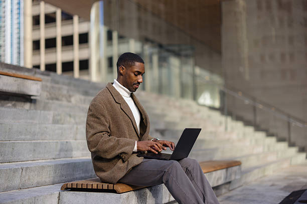 istock Businessman working on laptop outdoors in urban setting 2214138219