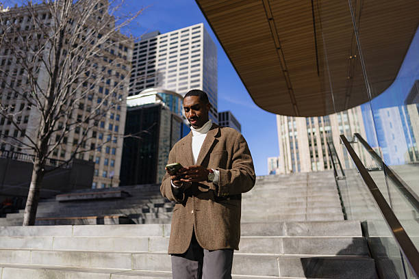 istock Businessman using smartphone on city steps in chicago 2214138221