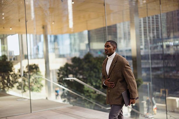 istock Businessman walking through modern office building holding laptop 2214138226
