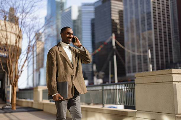 istock Businessman walking and talking on phone in city with notebook 2214138253