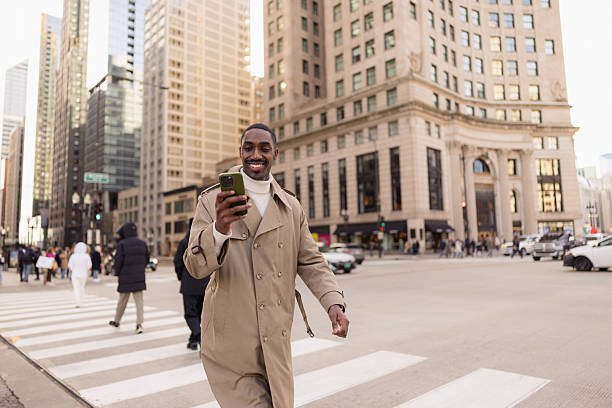 istock Businessman using phone while crossing street in chicago 2214138277