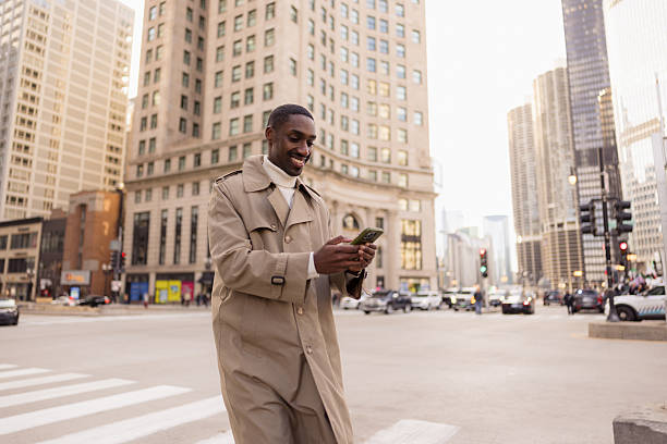 istock Smiling businessman using smartphone walking in chicago city center 2214138280
