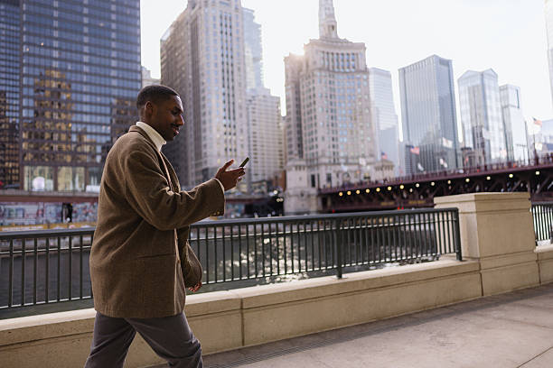 istock Businessman walking and using smartphone in chicago riverwalk 2214138282