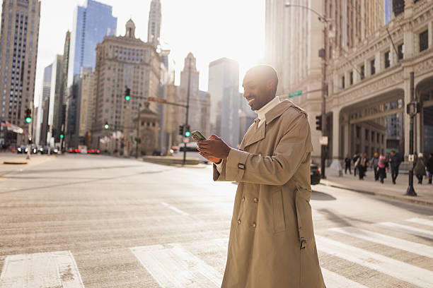 istock Smiling businessman using smartphone on chicago street at sunset 2214138290