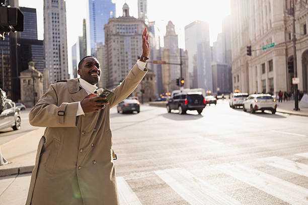 istock Businessman hailing cab in chicago using smartphone app 2214138299