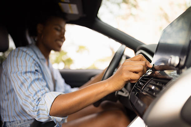 istock Young woman adjusting car stereo while driving 2214138414