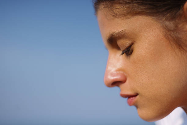 Close up of young woman shielding eyes