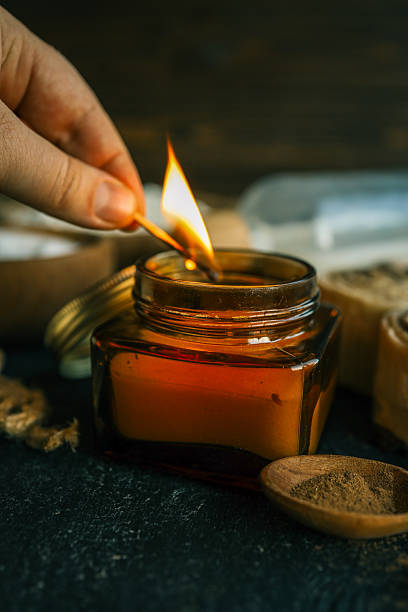 istock A hand lighting a candle in a cozy baking setup with cinnamon buns, flour, sugar, and eggs on a dark surface, ideal for warm kitchen scenes. 2214142285