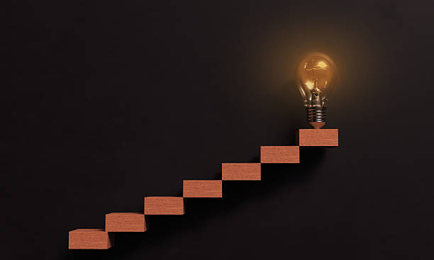 istock Ladder wooden step black color dark texture background wallpaper copy space lamp lightbulb orange color success business strategy education motivation progress growth achievement opportunity glowing 2214144638