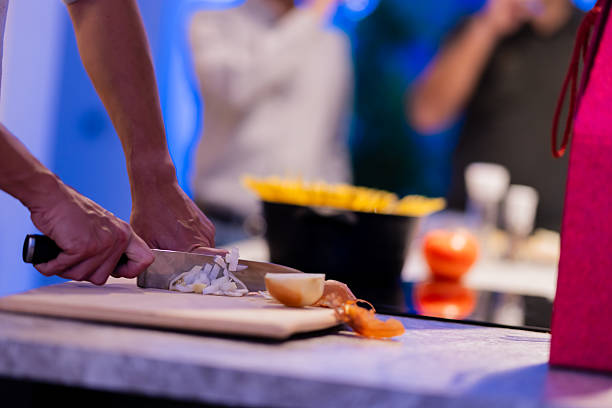 The image captures a knife slicing onions in a well-lit kitchen while preparing for a meal, emphasizing the meticulous nature of cooking.