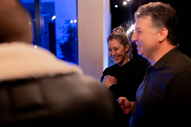istock A cheerful indoor gathering with people engaging in conversation and laughter beneath warm lighting. 2214145726