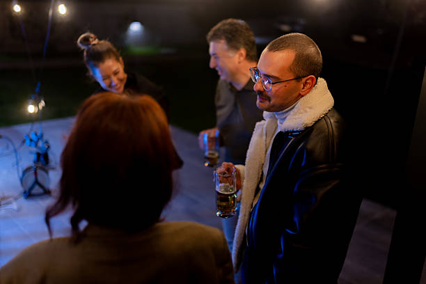 istock Group of friends enjoying an evening gathering outdoors with drinks and laughter 2214145728