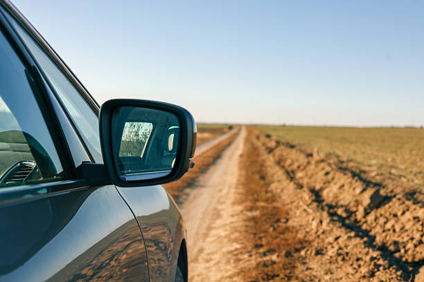 Car Side Mirror View of Tropical Travel on a Sea-Side Road in Palm Beach, Florida.