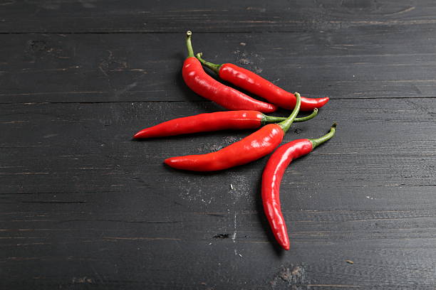 istock Fresh Red Chili Peppers on Dark Wooden Background 2214149234