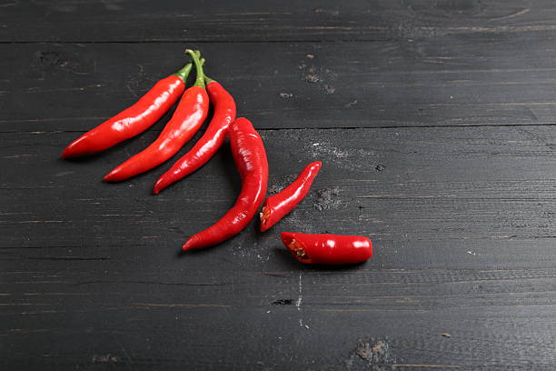 istock Fresh Red Chili Peppers on Dark Wooden Background 2214149249