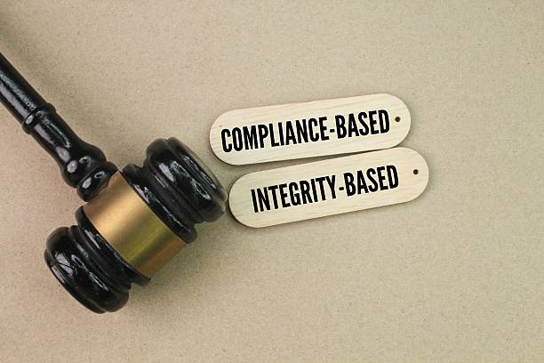 istock hammer and stick with the words compliance-based and integrity-based. Compliance refers to adherence to laws, regulations and internal policies, while Integrity reflects a company's ethical behavior 2214149520