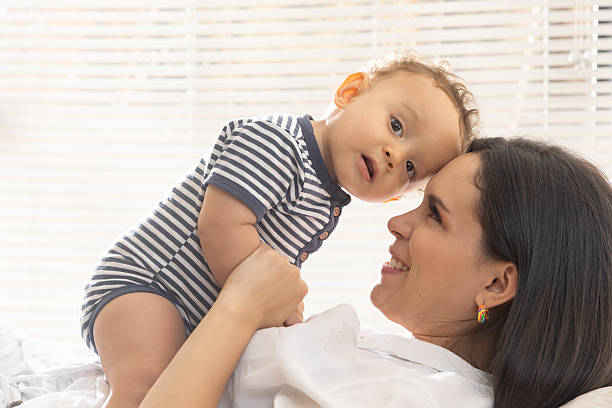 istock Young mother playing with her baby in a lighted room 2214152685