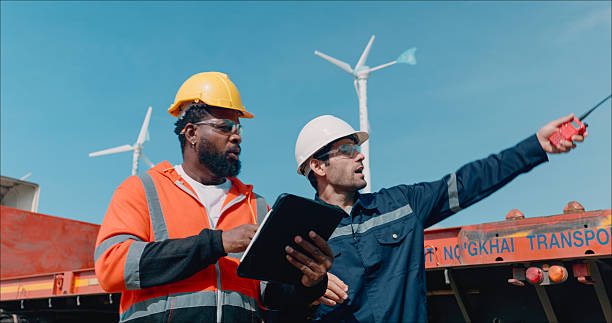 istock Caucasian man electrical engineer with Black Tecnicial discussing for maintenance of a wind turbine or windmill on the top of the wind turbine.Sustainability, renewable, clean energy concept. 2214155251