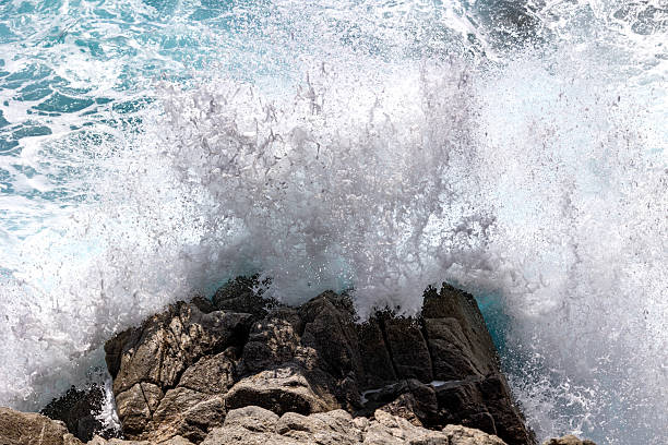 istock Massive ocean wave crashing into coastal rocks creating a dramatic splash of white foam 2214174017