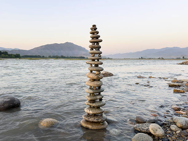 Stacked round stones sculpture artfully balanced in flowing river