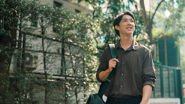 istock Young man walking in public park 2214180766
