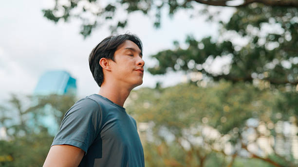 istock Asian man breathing inhaling good air 2214182443