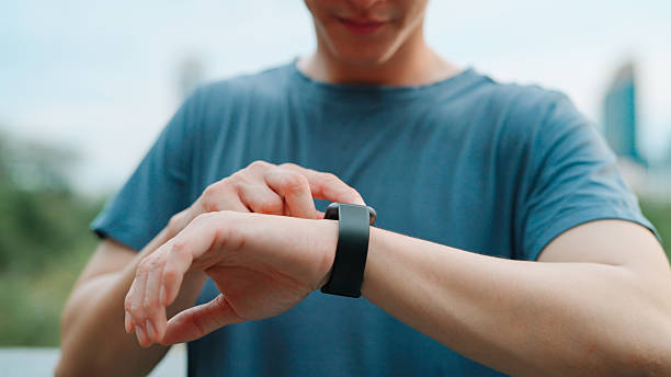istock Asian young man using smart watch in public park 2214182460
