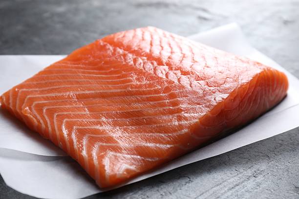 istock Piece of fresh salmon on grey table, closeup 2214182750