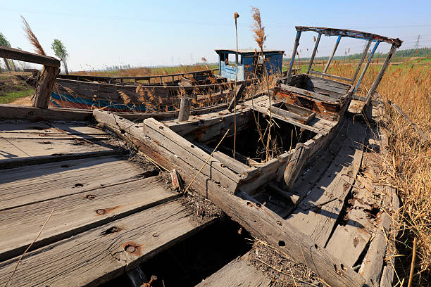 The broken wooden boat is on land
