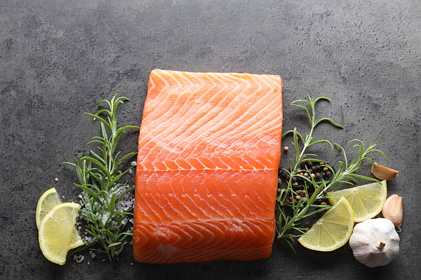 istock Piece of fresh salmon, lemon and spices on grey table, flat lay 2214182878