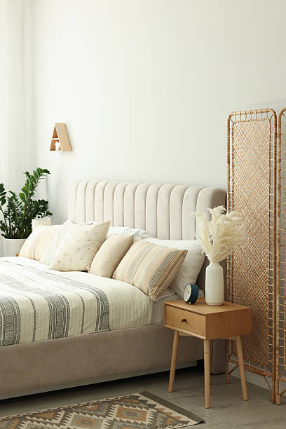 istock Large bed, houseplant and bedside table in stylish room 2214183245